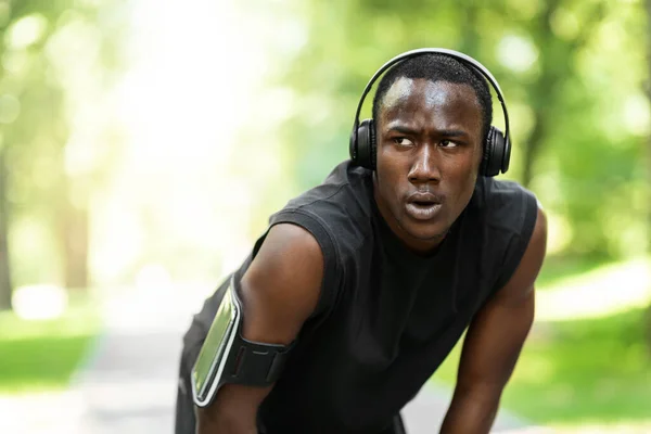 Cansado deportista africano tener un descanso durante el ejercicio en el parque —  Fotos de Stock