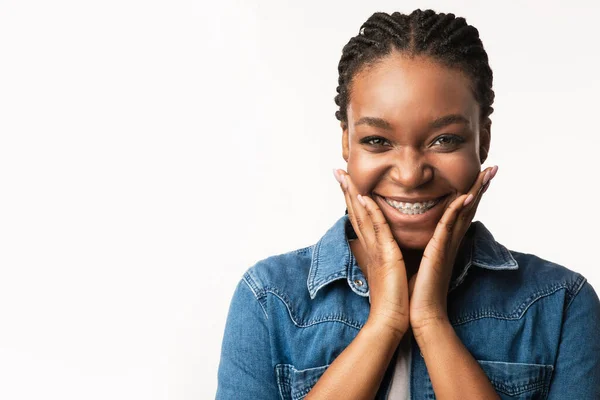 Menina preta com suportes Cupping rosto sorrindo para câmera, estúdio — Fotografia de Stock