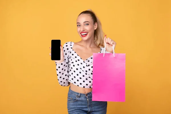 Radosna kobieta z torbą na zakupy i telefonem — Zdjęcie stockowe