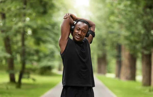 Sonriente deportista negro disfrutando de hacer ejercicio en el parque — Foto de Stock