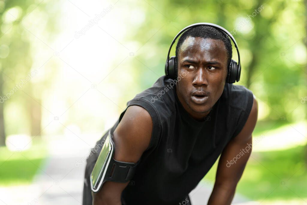 Tired african sportsman having break during exercising at park