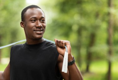 Parkta ip atlama eğitimi almış gülümseyen bir sporcu.