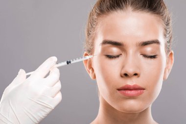 Göz kırışıklıkları için iğne yaptıran genç bir bayan.