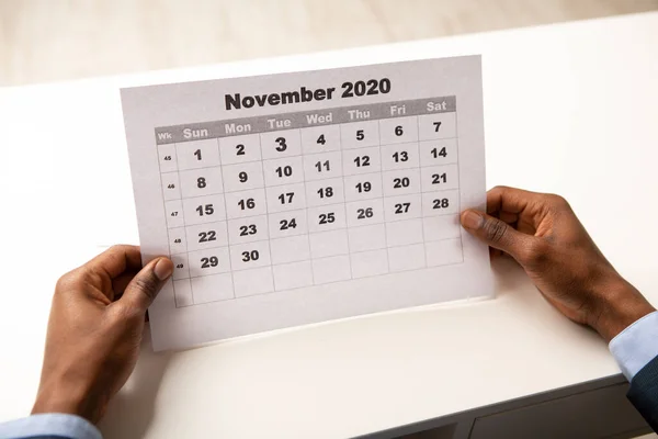 Αφρικανός που κοιτάζει το φύλλο ημερολογίου, Νοέμβριος 2020 — Φωτογραφία Αρχείου