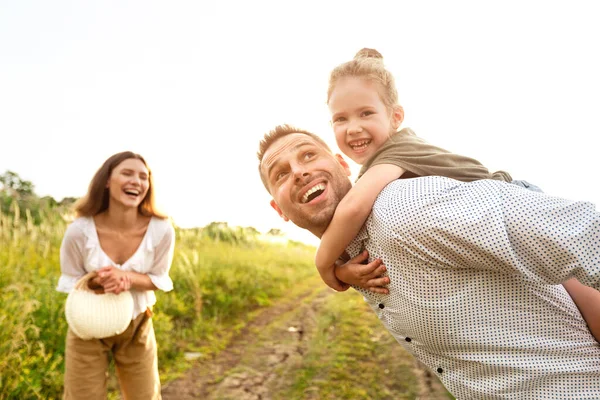 Lycklig familj leker tillsammans på fältet — Stockfoto