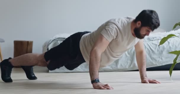 Joven barbudo haciendo flexiones, haciendo ejercicio en casa — Vídeos de Stock