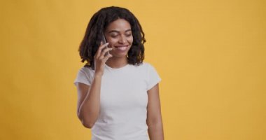 Mutlu Afro-Amerikalı kadın cep telefonuyla konuşuyor.