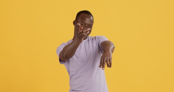 Speelse zwarte man schieten naar camera met handen en glimlachen — Stockvideo