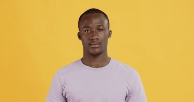 Yakışıklı, Afro-Amerikan bir adamın portresi, sarı arka plan.