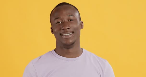 Flirttaileva afrikkalainen amerikkalainen mies lähettää ilmapusu kameralle — kuvapankkivideo