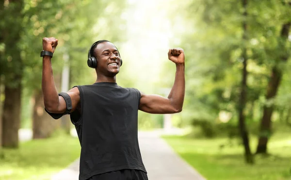 Black sportsman celebrating success, training at park — Stock Photo, Image