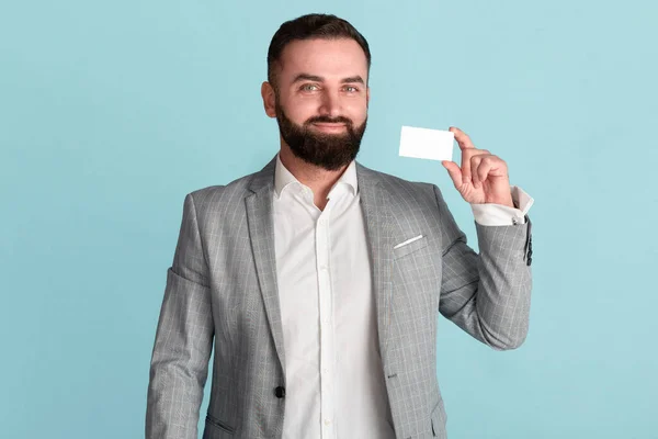 Glücklicher CEO zeigt Visitenkarte mit leerem Raum für Design vor blauem Hintergrund — Stockfoto