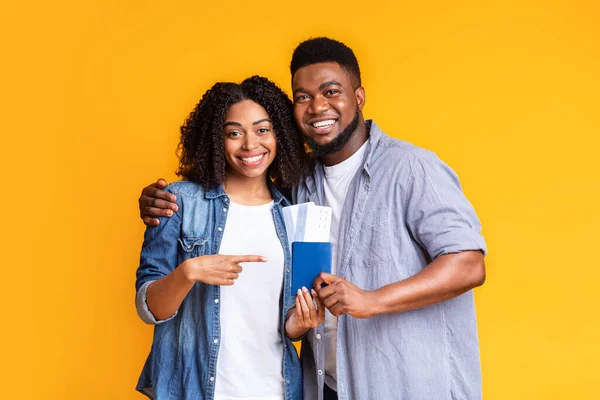 Tiempo para viajar. Cónyuges negros felices poniéndose en los pasaportes con billetes de avión — Foto de Stock