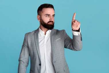 Yakışıklı milenyum işletme sahibi mavi arkaplan üzerinde etkileşimli ekrana dokunuyor, tasarım için alan