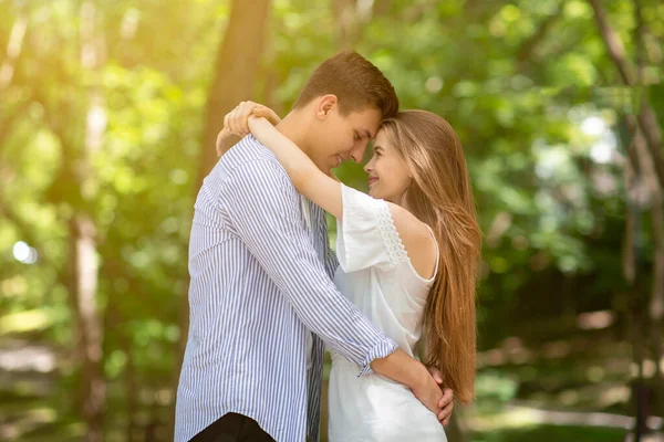 Молодая супружеская пара наслаждается своим временем вместе, обнимаясь в парке — стоковое фото