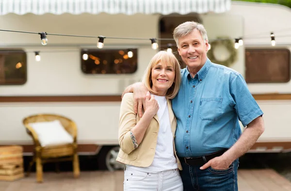 Portrait of mature couple embracing near their motorhome at campground, copy space — Stock Photo, Image