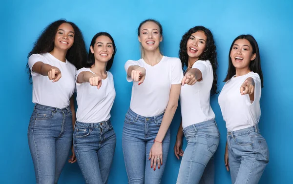 Multiethnische Mädchen zeigen mit dem Finger auf Kamera über blauem Hintergrund, Studio — Stockfoto