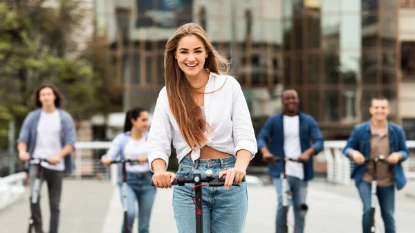 Cinco jovens amigos tendo passeio em e-scooters ao ar livre — Fotografia de Stock