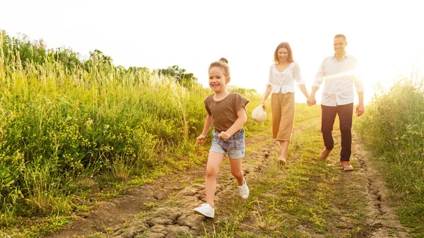 Glückliche Eltern und Kind spazieren im Sommer gemeinsam im Freien — Stockfoto