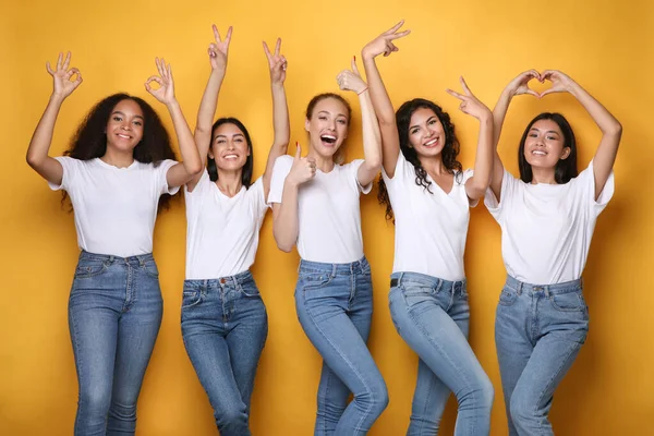 Allegro Diverse donne Gesto Simboli Sorridente in piedi su sfondo giallo — Foto Stock