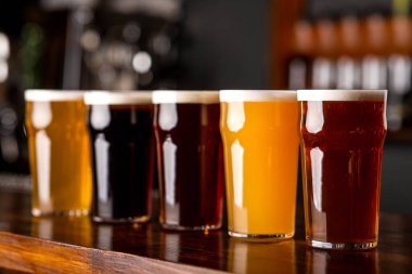 Koyu, açık, arpa, bira ve bira bardakta tezgahta.