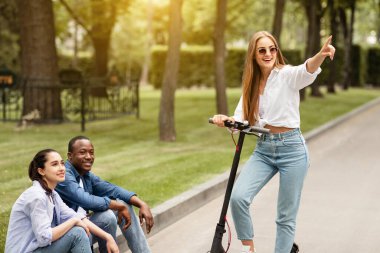 Gün batımında motosiklete binen bir kız.