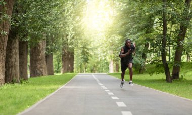 Siyah adam parkta koşuyor, maratona hazırlanıyor.