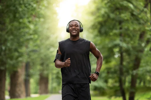 Χαρούμενος Αφρικανός αθλητής που απολαμβάνει την πρωινή του άσκηση στο πάρκο. — Φωτογραφία Αρχείου