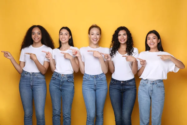 Cinco mulheres multirraciais apontando os dedos além de anunciar algo, tiro no estúdio — Fotografia de Stock