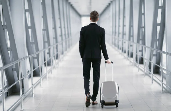 Hombre de negocios urbano caminando en el aeropuerto con maleta — Foto de Stock
