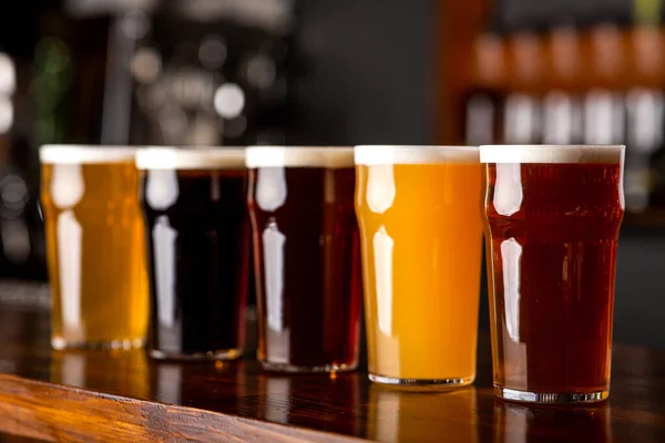 Koyu, açık, arpa, bira ve bira bardakta tezgahta. — Stok fotoğraf