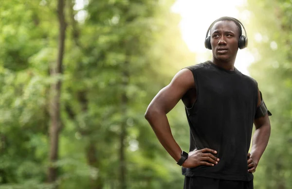 Guapo deportista negro con auriculares mirando espacio de copia —  Fotos de Stock