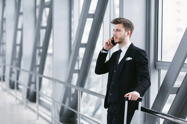 Homme d'affaires sérieux parlant sur smartphone à l'aéroport — Photo