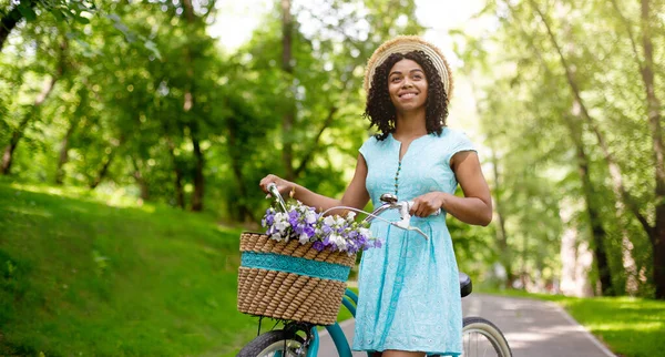 Millennial Αφροαμερικανή γυναίκα με ποδήλατο στο πάρκο την καλοκαιρινή μέρα, κενό χώρο — Φωτογραφία Αρχείου
