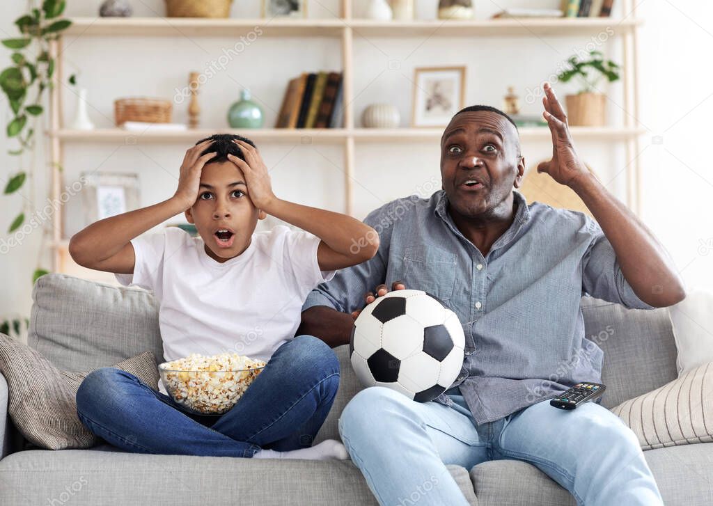 Lost Goal. Disappointed Black Grandfather And His Grandson Watching Football On TV