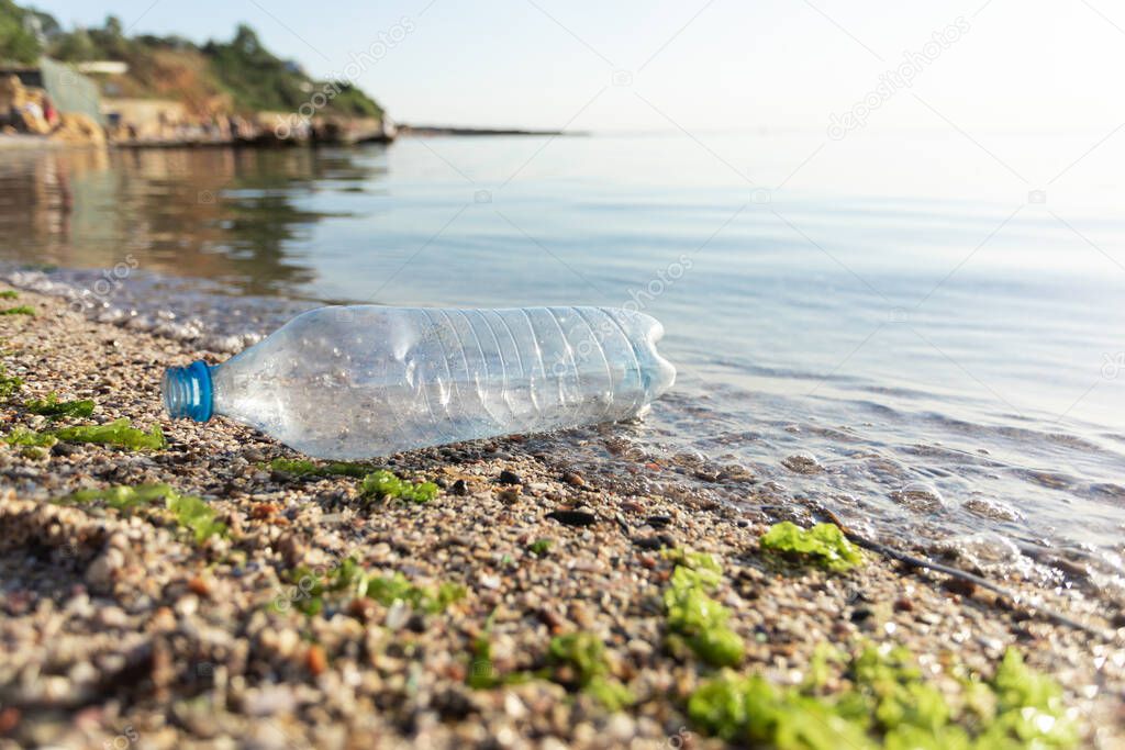 Plastic Bottle Floating In Water Near Seashore, Beach Pollution Background
