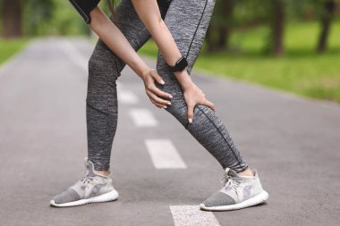 Baldır yaralanması. Sportif bir kadın bacağına masaj yapıyor, dışarıda koştuktan sonra kas ağrısı çekiyor.