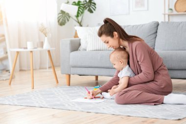 Bebekler için Erken Gelişim. Anne, küçük oğluyla evde çizim yapıyor.
