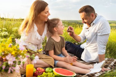 Mutlu baba çocuğunu üzümle besliyor.
