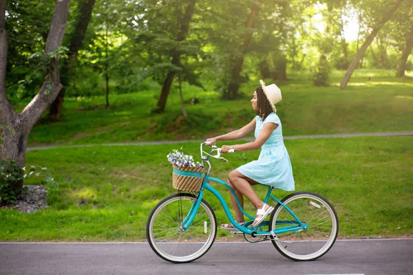 Πλευρική άποψη της νεαρής μαύρης γυναίκας πρόκειται για βόλτα με το ποδήλατο στο πάρκο το καλοκαίρι, αντίγραφο χώρο — Φωτογραφία Αρχείου