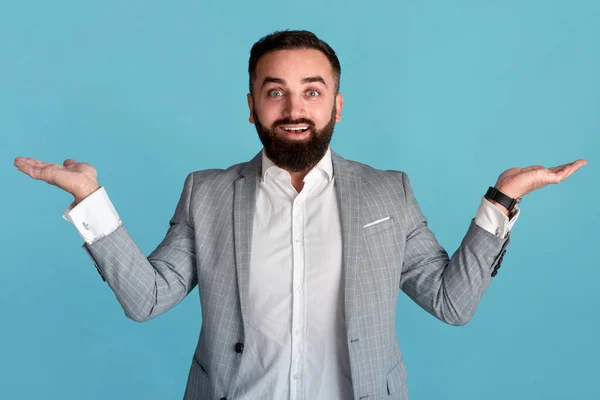 Hombre de negocios alegre presentando o comparando productos, haciendo gestos de balanzas con manos sobre fondo azul, espacio para copiar —  Fotos de Stock