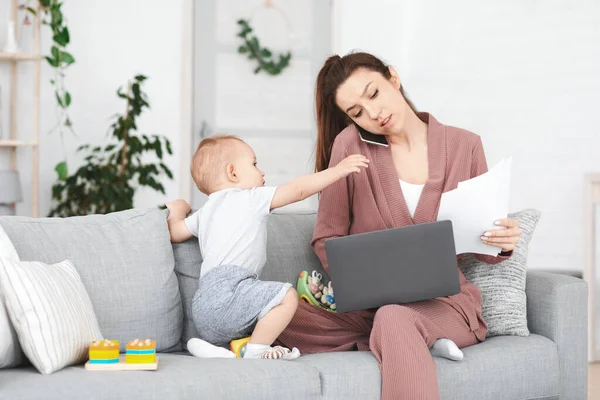 Affärer och moderskap. Irriterad mamma försöker arbeta medan småbarn distrahera henne — Stockfoto