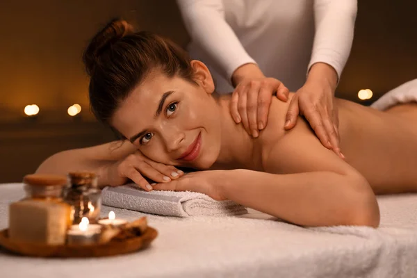 Щаслива дівчина насолоджується ароматерапією та лікувальним масажем у спа-центрі — стокове фото
