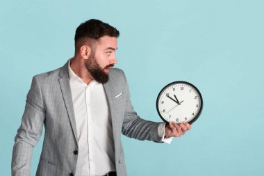 Zaman yönetimi sorunu. Analog saati olan korkmuş bir şirket çalışanı mavi arka planda son teslim tarihi eksik.