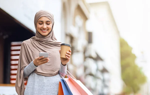 Telefonla alışveriş torbalarıyla neşeli Müslüman kız. — Stok fotoğraf