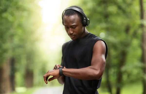 Černý atletický chlap pracuje s fitness náramek — Stock fotografie