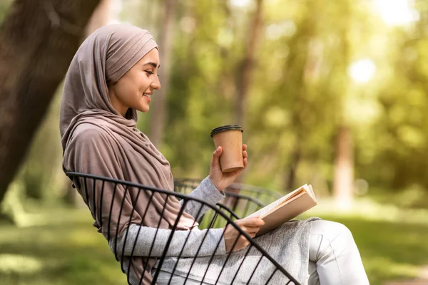 Foto de perfil de chica árabe leyendo libro en el parque de la ciudad —  Fotos de Stock