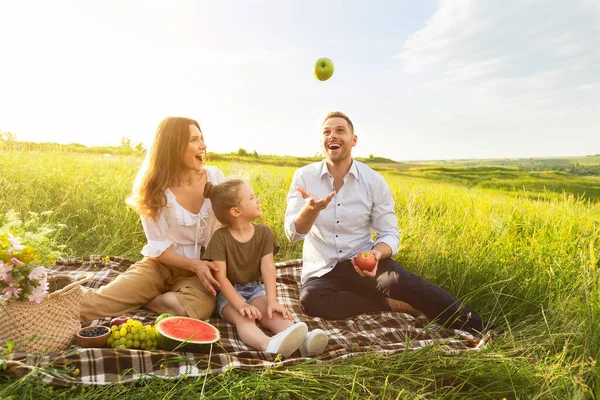 Spännande pappa jonglerar med äpplen på picknick utomhus — Stockfoto