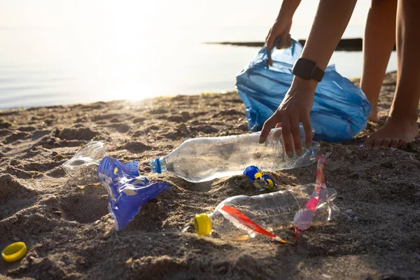 Voluntária feminina limpeza poluída praia coletando lixo plástico ao ar livre, cortada — Fotografia de Stock