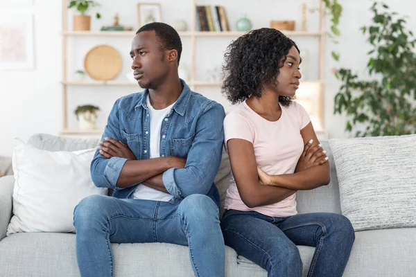 Ofendido marido e mulher negros sentados no sofá em casa — Fotografia de Stock